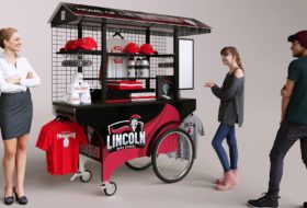 A red and black portable push cart for vending high school team swag.