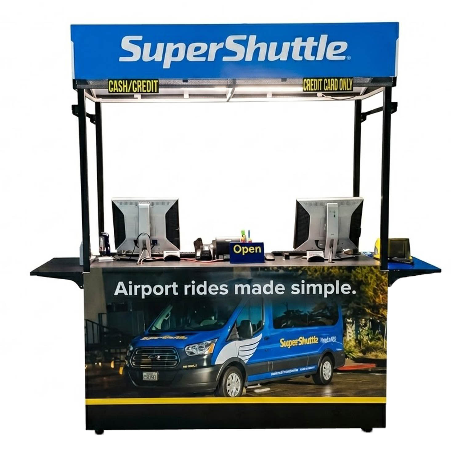 SuperShuttle retail kiosk with blue branding, canopy LED light, cash and credit signage, and a van wrap graphic.