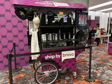 A push cart wrapped in an eye catching purple vinyl to sell branded merchandise at a trade show
