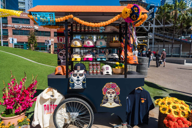 San Diego Padres retail merchandise pushcart displaying team baseball caps and apparel outdoors